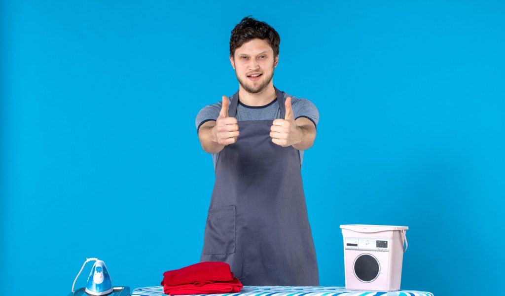 front-view-young-male-with-ironing-board-and-clothes-on-blue-background-color-housework-laundry-cleaning-washing-machine